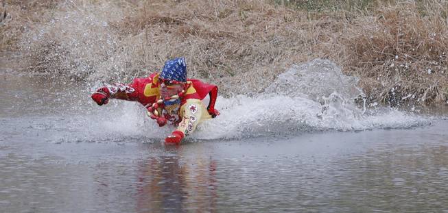 Kansas City Chiefs fan Ty Rowton, known as XFactor, takes a Plunge for Landon in a farm pond near Bonner Springs, Kan., Friday, April 4, 2014. A 5-month-old boy's battle with cancer has inspired hundreds to jump into cold bodies of water, from a local golf course pond to the Gulf of Mexico and even the Potomac River in Washington, D.C.