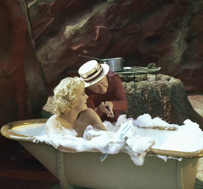  Mickey Rooney wearing costume for role in movie "The Private Lives of Adam & Eve." Rooney plays the part of the devil. Girl in the tub is British Actress Joan Wilkinson. The movie story is about people stranded by a flood on the way to Reno, Nevada, with bus passengers becoming Adam, Eve, and the devil in a dream. Within the Garden of Eden the story has Vaudevillian skits involving Mickey Rooney as Satan. This photo is dated September 8, 1959.