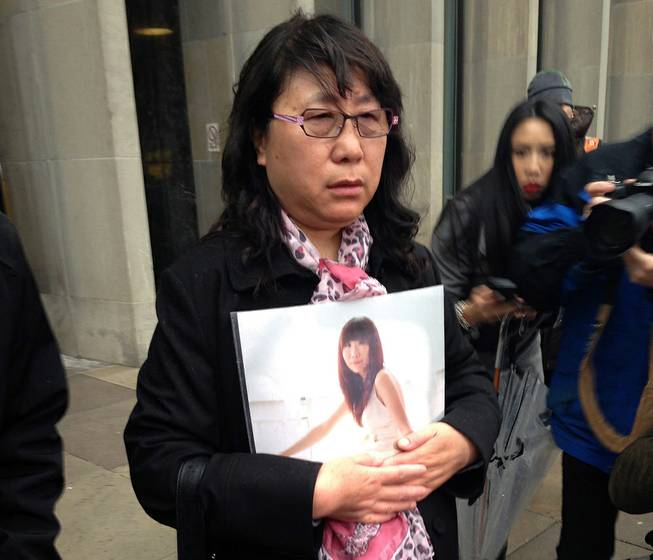 Ya Ru Zheng holds a photo of her daughter Qian Liu outside a courthouse in Toronto, on Monday, April 7, 2014. A jury has found 32-year-old Brian Dickson guilty of first-degree murder in the death of York University student Liu, from China. 