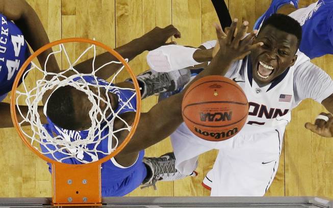 Kentucky forward Julius Randle, left, and Connecticut center Amida Brimah go after the ball during the second half of the NCAA Final Four tournament college basketball championship game Monday, April 7, 2014, in Arlington, Texas. (AP Photo/David J. Phillip)