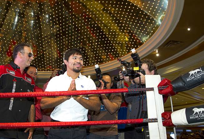 Boxer Manny Pacquiao of the Philippines acknowledges fans from a ring in the lobby of the MGM Grand Tuesday, April 8, 2014. Pacquiao will challenge undefeated WBO welterweight champion Timothy Bradley at the MGM Grand Garden Arena on Saturday. The fight is a rematch to a June 9, 2012 fight that Bradley won.