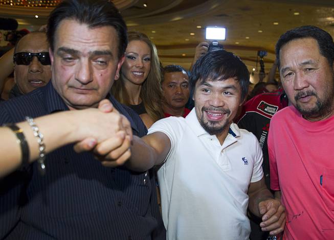Boxer Manny Pacquiao of the Philippines greets a fan as he makes his official arrival at the MGM Grand Tuesday, April 8, 2014. Pacquiao will challenge undefeated WBO welterweight champion Timothy Bradley at the MGM Grand Garden Arena on Saturday. The fight is a rematch to a June 9, 2012 fight that Bradley won.