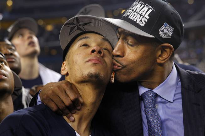 Connecticut head coach Kevin Ollie gives his star player Shabazz Napier (13) a kiss while the watch the "One Shining Moment' video following their 60-54 win over the Kentucky Wildcats in the NCAA National Basketball Championship at AT&T Stadium in Arlington, Texas on Monday, April 7, 2014. 