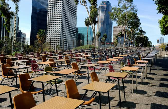School desks placed by parents, district graduates and activists block a street in front of Los Angeles Unified School District headquarters in a demonstration against student dropout rates Tuesday, April 8, 2014, in downtown Los Angeles. 