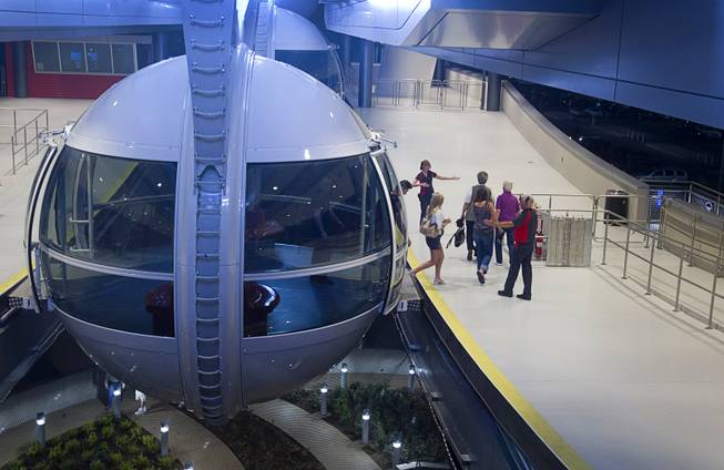 Passengers depart a cabin after riding the 550 foot-tall High Roller observation wheel, the tallest in the world, Wednesday, April 9, 2014. The wheel is the centerpiece of the $550 million Linq project, a retail, dining and entertainment district by Caesars Entertainment Corp.