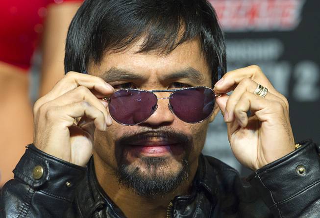 Boxer Manny Pacquiao of the Philippines takes off his sunglasses during a news conference at the MGM Grand Wednesday, April 9, 2014. Pacquiao will challenge undefeated WBO welterweight champion Timothy Bradley at the MGM Grand Garden Arena on Saturday. The fight is a rematch to a June 9, 2012 fight that Bradley won.