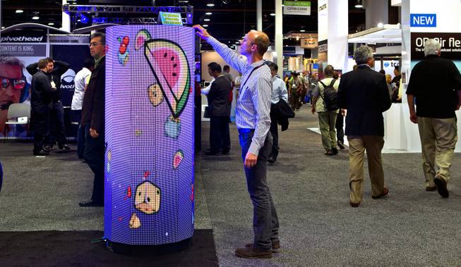 A P6 Indoor Cylinder from the DesignLED Technology Co. has a flexible LED screen attracting the curious during the National Association of Broadcasters show at the Las Vegas Convention Center on Tuesday, April 8, 2014.
