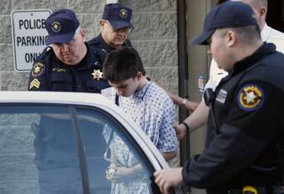 Alex Hribal, center, the suspect in the stabbings at the Franklin Regional High School near Pittsburgh, is taken from a district magistrate after he was arraigned on charges in the attack on Wednesday, April 9, 2014 in Export, Pa. Authorities say Hribal has been charged after allegedly stabbing and slashing at least 19 people, mostly students, in the crowded halls of his suburban Pittsburgh high school Wednesday. 