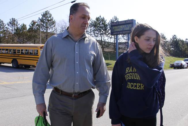 Jenna Mickel, right, a sophomore at Franklin Regional High School, right, stands with her father, Richard, as she talks with reporters near the school, where several people were stabbed, Wednesday, April 9, 2014, in Murrysville, Pa., near Pittsburgh. The suspect, a male student, was taken into custody and being questioned.