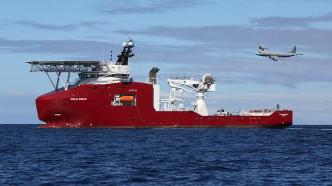 In this April 9, 2014, photo provided by the Australian Defense Force, a Royal Australian Air Force AP-3C Orion flies past Australian Defense vessel Ocean Shield on a mission to drop sonar buoys to assist in the acoustic search of the missing Malaysia Airlines Flight 370 in the southern Indian Ocean.