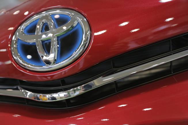 In this Aug. 2, 2013, photo, the emblem of a Toyota car shines at Toyota Motor Corp.'s showroom Toyota Mega Web in Tokyo.