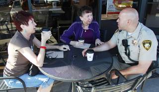 Michelle Bresette, left, and Jan Primavera talk with Metro officer Danny Cordero during a 