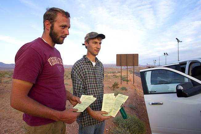 Brothers Tyler Shillig, left , and Spencer Shillig, of St. George, Utah, show their citations after being cited by Bureau of Land Management  officers in the Lake Mead National Recreation Area near Overton Thursday, April 10, 2014.