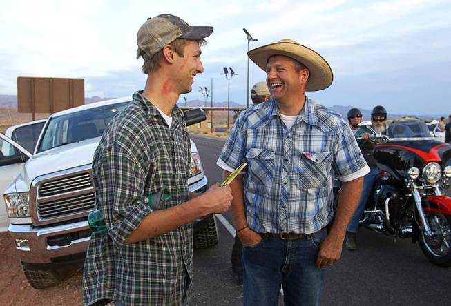 Spencer Shillig, left, of St. George, Utah talks with Ammon Bundy being cited by Bureau of Land Management officers in the Lake Mead National Recreation Area near Overton Thursday, April 10, 2014.