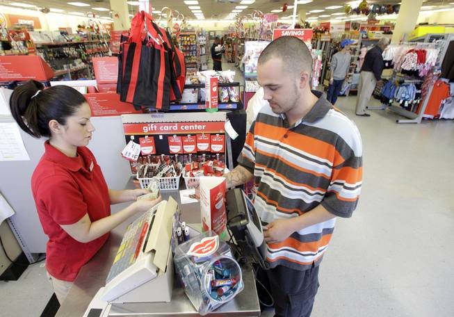 In this photo taken Dec. 14, 2010, Family Dollar employee Pamela Ramos assists John Conner with a purchase at a store in Waco, Texas. Family Dollar on Thursday, April 10, 2014, said it will be cutting jobs and closing about 370 underperforming stores as it looks for ways to improve its financial performance.