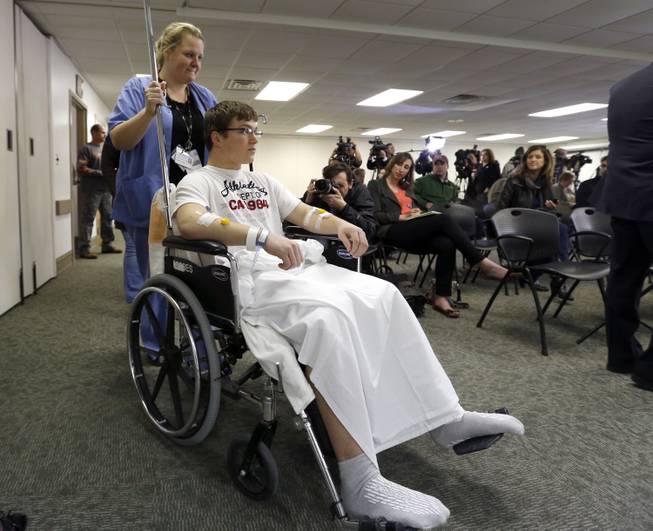 Brett Hurt, a sophomore at Franklin Regional High School in Murrysville, Pa., is wheeled into a news conference by a nurse at Forbes Hospital Thursday, April 10, 2014, in Monroeville, Pa.