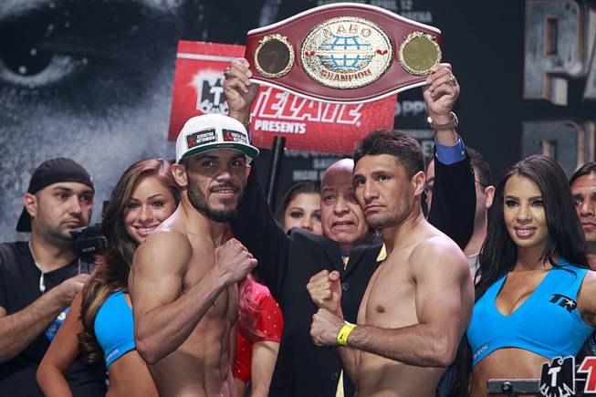 Super featherweight boxers Raymundo Beltran, left, of Mexico and Arash Usmanee of Canada (originally Afghanistan) pose during an official weigh-in at the MGM Grand Garden Arena Friday, April 11, 2014. The boxers will fight in a 10-round lightweight bout.