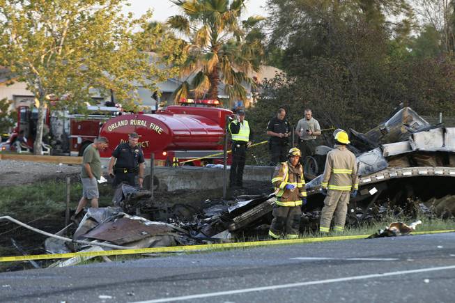 Emergency crews look over wreckage from a crash between a semi and a tour bus on Thursday, April 10, 2014, on Interstate 5 near Orland, Calif. 