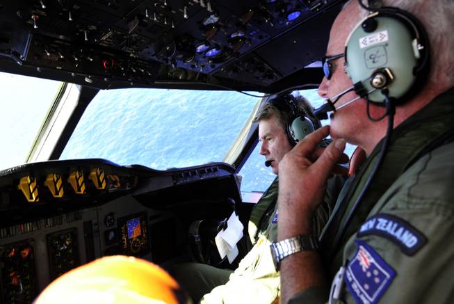 Royal New Zealand Air Force co-pilot and squadron leader Brett McKenzie, left, and flight engineer Trent Wyatt sit in the cockpit aboard a P-3 Orion en route to search the southern Indian Ocean for missing Malaysia Airlines Flight 370, Friday, April 11, 2014.