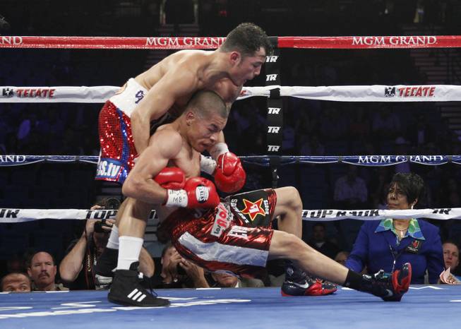 Bryan Vazquez grabs Jose Felix as Felix slips to the canvas during their WBA interim super featherweight fight at the MGM Grand Garden Arena on Saturday, April 12, 2014.
