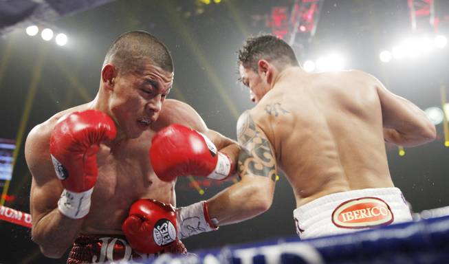 Jose Felix gets hit with a body shot by Bryan Vazquez during their WBA interim super featherweight fight at the MGM Grand Garden Arena on Saturday, April 12, 2014.