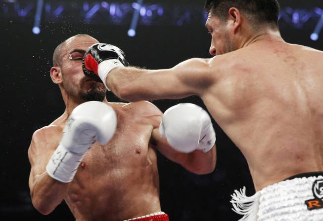 Arash Usmanee, right, hits Ray Beltran with a left during a 10-round lightweight fight at the MGM Grand Garden Arena on Saturday, April 12, 2014.