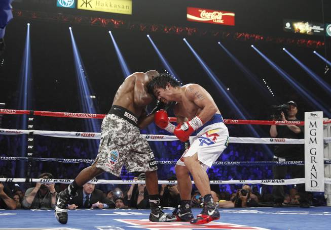Manny Pacquiao, right, and undefeated WBO welterweight champion Timothy Bradley battle during their title fight at the MGM Grand Garden Arena on Saturday, April 12, 2014.