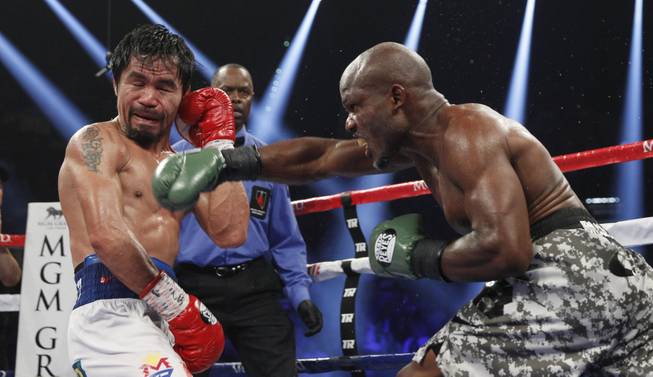 Manny Pacquiao is hit by undefeated WBO welterweight champion Timothy Bradley during their title fight at the MGM Grand Garden Arena on Saturday, April 12, 2014. Pacquiao won by unanimous decision.