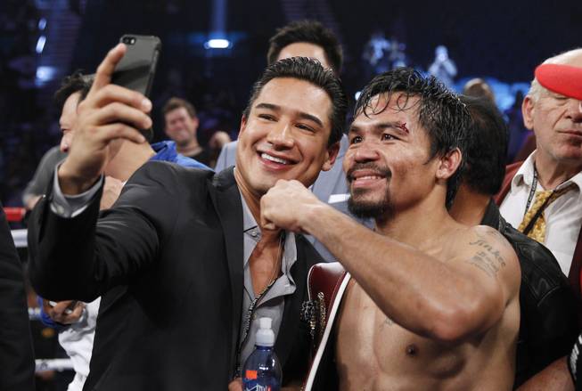 Manny Pacquiao, right, takes a photo with actor Mario Lopez as he celebrates his unanimous decision over WBO welterweight champion Timothy Bradley during their title fight at MGM Grand Garden Arena on Saturday, April 12, 2014. Bradley was previously undefeated.