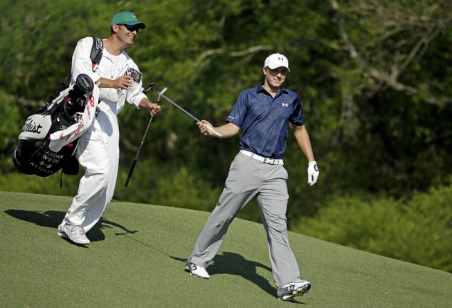 Jordan Spieth gets his putter from caddie Michael Greller after teeing off on the 12th hole during the third round of the Masters golf tournament Saturday, April 12, 2014, in Augusta, Ga. 