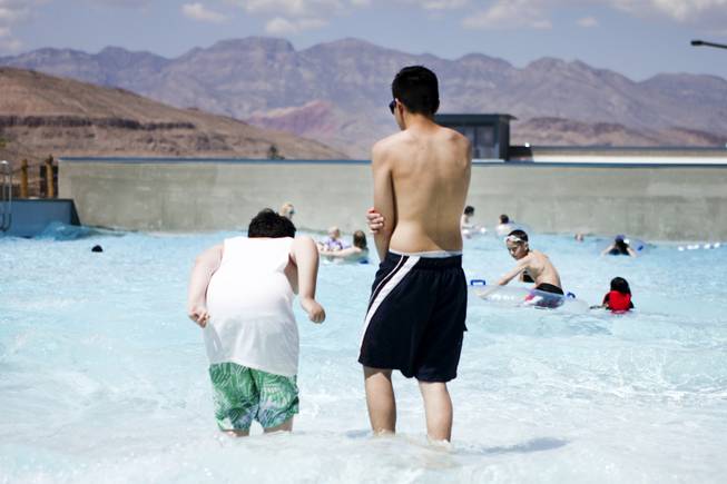 Red Rock Canyon is seen in the background as a couple of boys enjoy the wave pool at Wet 'n' Wild during the first day of its weeklong spring break opening Saturday, April 12, 2014.