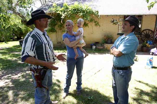 Ryan Bundy, left, one of Cliven Bundy's sons, talks with David Lory VanDerBeek, an Independent American Party candidate for governor, at the family ranch near Bunkerville Sunday, April 13, 2014. Ryan's wife Angela holds their son Moroni, 2, at center. 