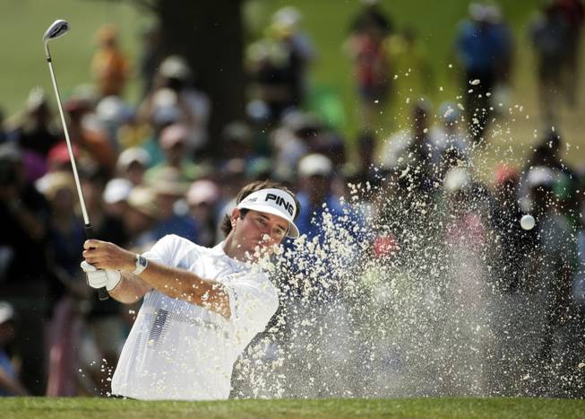 Bubba Watson hits out of a bunker on the seventh hole during the fourth round of the Masters golf tournament Sunday, April 13, 2014, in Augusta, Ga.