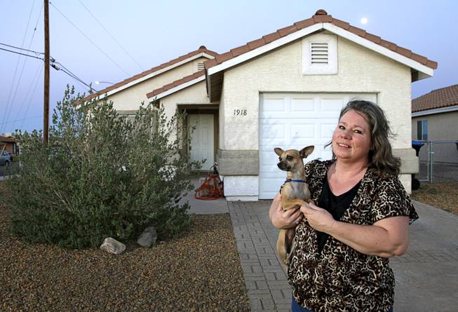 Liz Epperson poses with her dog Mi Corazon, a four-year-old chihuahua, in front of her home in Henderson Sunday, April 13, 2014. Epperson put 450 hours of sweat equity into the house which was built in 1997, she said.