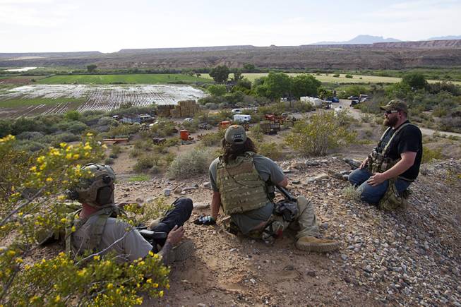 Jim (no last name provided) of Las Vegas, Reid Hendricks, center, of Camden, Tenn. and Ian Houston of Eugene, Ore.  take up a position on a hill by Cliven Bundy's ranch near Bunkerville Tuesday, April 15, 2014. Hendricks is a former Marine (honorably discharged), and has worked as a police officer and a high school history teacher, he said.