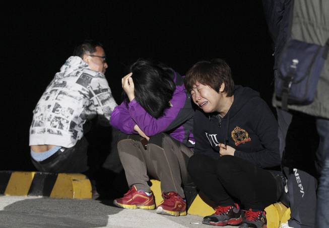 A relative weeps as she waits for missing passengers of a sunken ferry at Jindo port, South Korea, Wednesday, April 16, 2014. The ferry carrying 459 people, mostly high school students on an overnight trip to a tourist island, sank off South Korea's southern coast on Wednesday, leaving nearly 300 people missing despite a frantic, hours-long rescue by dozens of ships and helicopters.