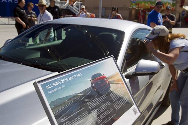 A woman looks into the redesigned 2015 Ford Mustang during the Mustang 50th Birthday Celebration at the Las Vegas Motor Speedway Thursday, April 17, 2014. The celebration continues through Sunday.