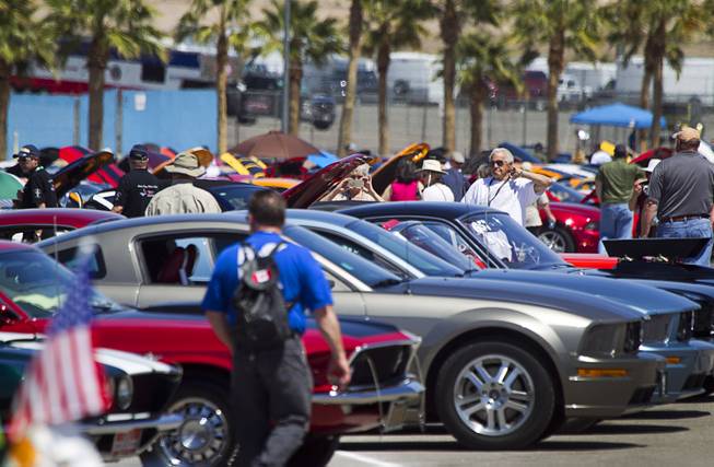 Visitors walk through a parking lot filled with hundreds of late-model and classic Mstangs during the Mustang 50th Birthday Celebration at the Las Vegas Motor Speedway Thursday, April 17, 2014.