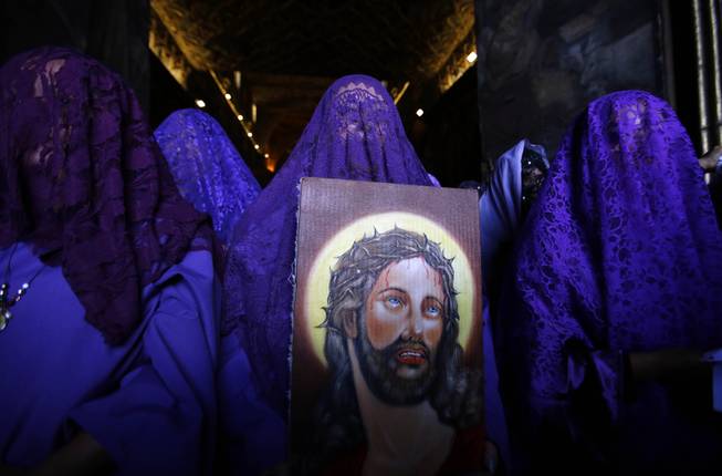 Female penitents called "Veronicas" participate in a Good Friday procession carrying an image of Jesus in Quito, Ecuador, Friday, April 18, 2014. Holy Week commemorates the last week of the earthly life of Jesus Christ, culminating in his crucifixion on Good Friday and his resurrection on Easter Sunday. (AP Photo/Dolores Ochoa)