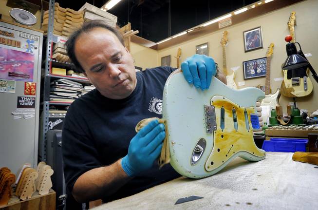 Fender Custom Shop Master Builder John Cruz works on a heavily-used Fender Stratocaster body at the Fender factory in Corona, Calif. on Tuesday, Oct. 15, 2013. Leo Fender developed the instrument in a small workshop in Fullerton, Calif. six decades ago.