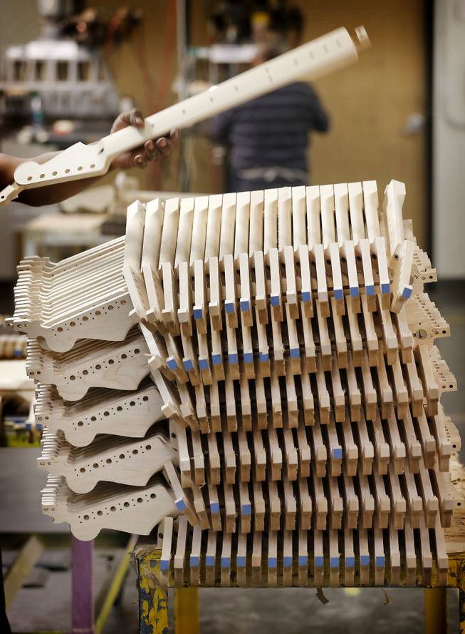 Fender Stratocaster electric guitar necks are prepared for assembly at the Fender factory in Corona, Calif. Leo Fender developed the instrument in a small workshop in Fullerton, Calif. six decades ago.