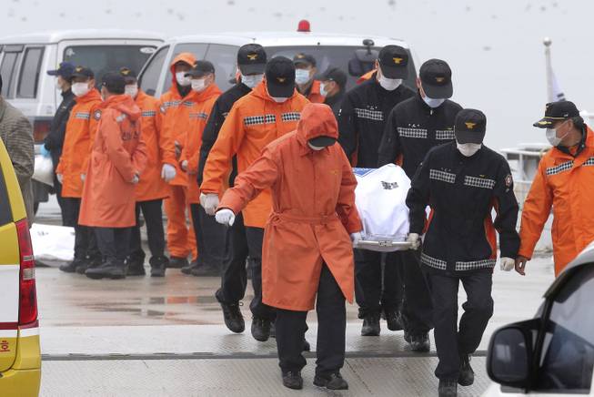 Rescue workers carry the body of a passenger aboard The Sewol ferry which sank in the water off the southern coast, at a port in Jindo, South Korea, Friday, April 18, 2014.