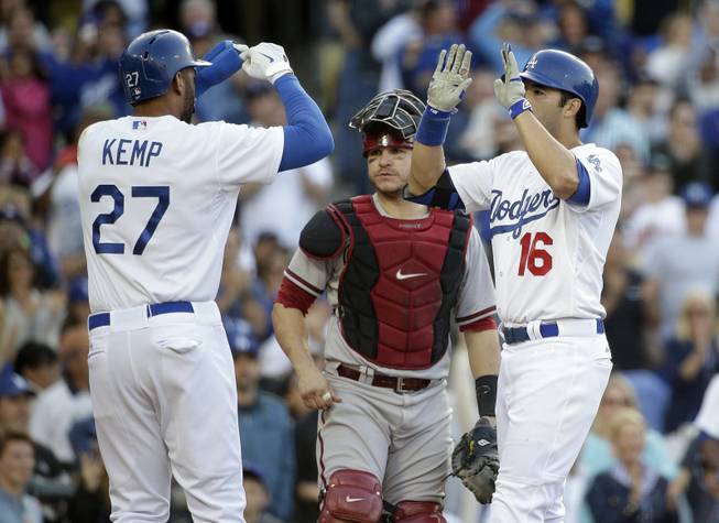 Los Angeles Dodgers outfielders Andre Ethier, right, and Matt Kemp, left, celebrate a three-run home run hit by Ethier in front of Arizona Diamondbacks catcher Miguel Montero during the fourth inning of a baseball game Saturday, April 19, 2014, in Los Angeles.