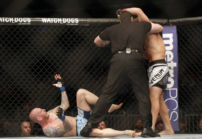 The referee stops the fight in the first round between Luke Zachrich, bottom, and Caio Magalhaes of Brazil in a mixed martial arts event on Saturday, April 19, 2014, at UFC Fight Night in Orlando, Fla. Magalhaes won.