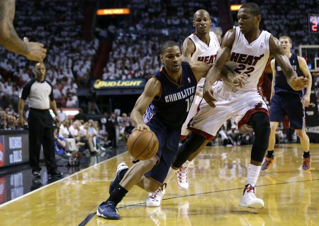 Charlotte Bobcats' Gary Neal (12) drives to the basket as Miami Heat's James Jones (22) defends during the second half in Game 1 of an opening-round NBA basketball playoff series on Sunday, April 20, 2014, in Miami. The Heat defeated the Bobcats 99-88.