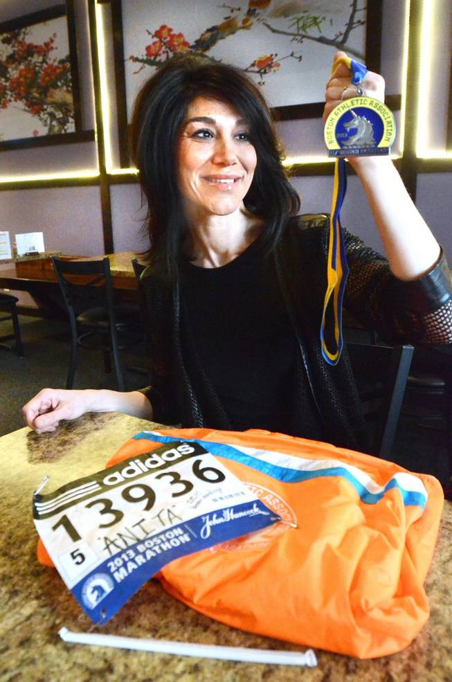 Anita Harless of Holly Township, Mich., shows her medal and runner's number from the 2013 Boston Marathon. Harless finished the race before the bombings and is going to run in this year's race despite the bad memories associated with that day, Harless decided to pay homage to those who can’t be there. She said she needs to attend it as “closure.” 