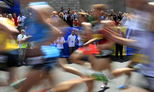 Spectators cheer runners in the Invitational Mile on Saturday, April 19, 2014, in Boston, in advance of Monday's 118th Boston Marathon. 