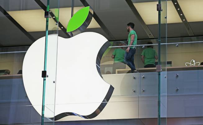 Employees wear green shirts near Apple's familiar logo displayed with a green leaf at the Apple Store timed to coincide with an annual celebration of Earth Day in Sydney, Tuesday, April 22, 2014. 