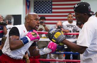 WBC welterweight champion Floyd Mayweather Jr., left, works on his timing with his uncle and trainer Roger Mayweather at the Mayweather Boxing Club Tuesday, April 22, 2014. Mayweather is preparing for his fight against WBA champion Marcos Maidana of Argentina at the MGM Grand Garden Arena on May 3.