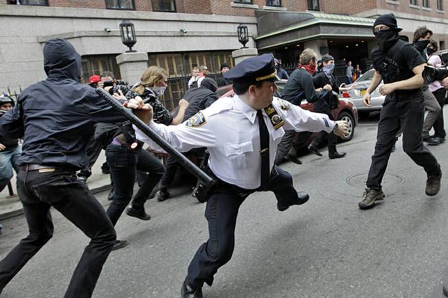 A police lieutenant swings his baton at Occupy Wall Street activists in New York, May 1, 2012. This photo is among the many put on Twitter in response to a New York Police Department request for Twitter users to share pictures of themselves posing with police officers. 